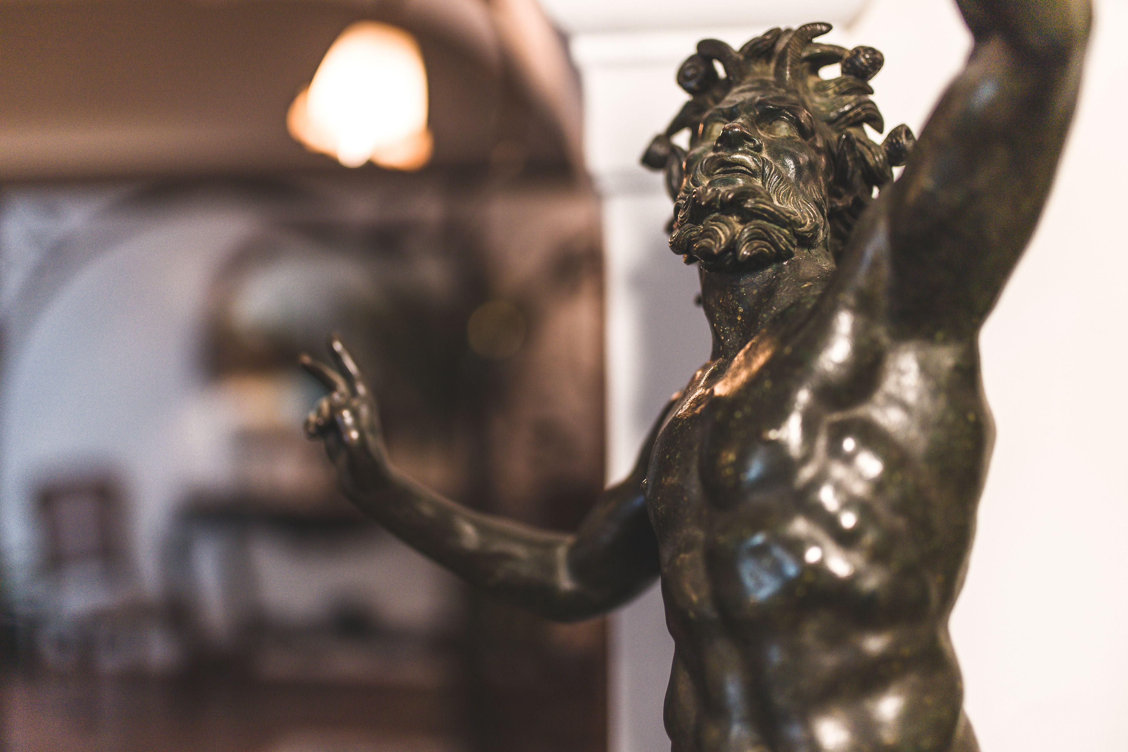 Una estàtua de bronze d'una figura musculosa amb els braços aixecats, possiblement en un espai públic o una galeria.