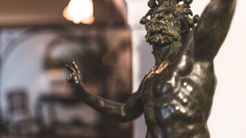 Una estàtua de bronze d'una figura musculosa amb els braços aixecats, possiblement en un espai públic o una galeria.