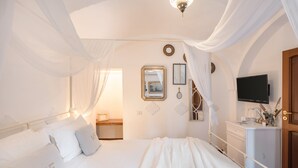 A bedroom with a bed, a bedside table, a TV, and a wardrobe. - Maison Fernanda (Massa Lubrense)