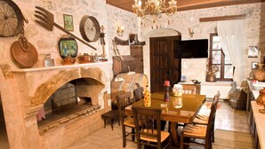 Una chimenea de piedra rústica con una mesa y sillas de madera en un comedor.