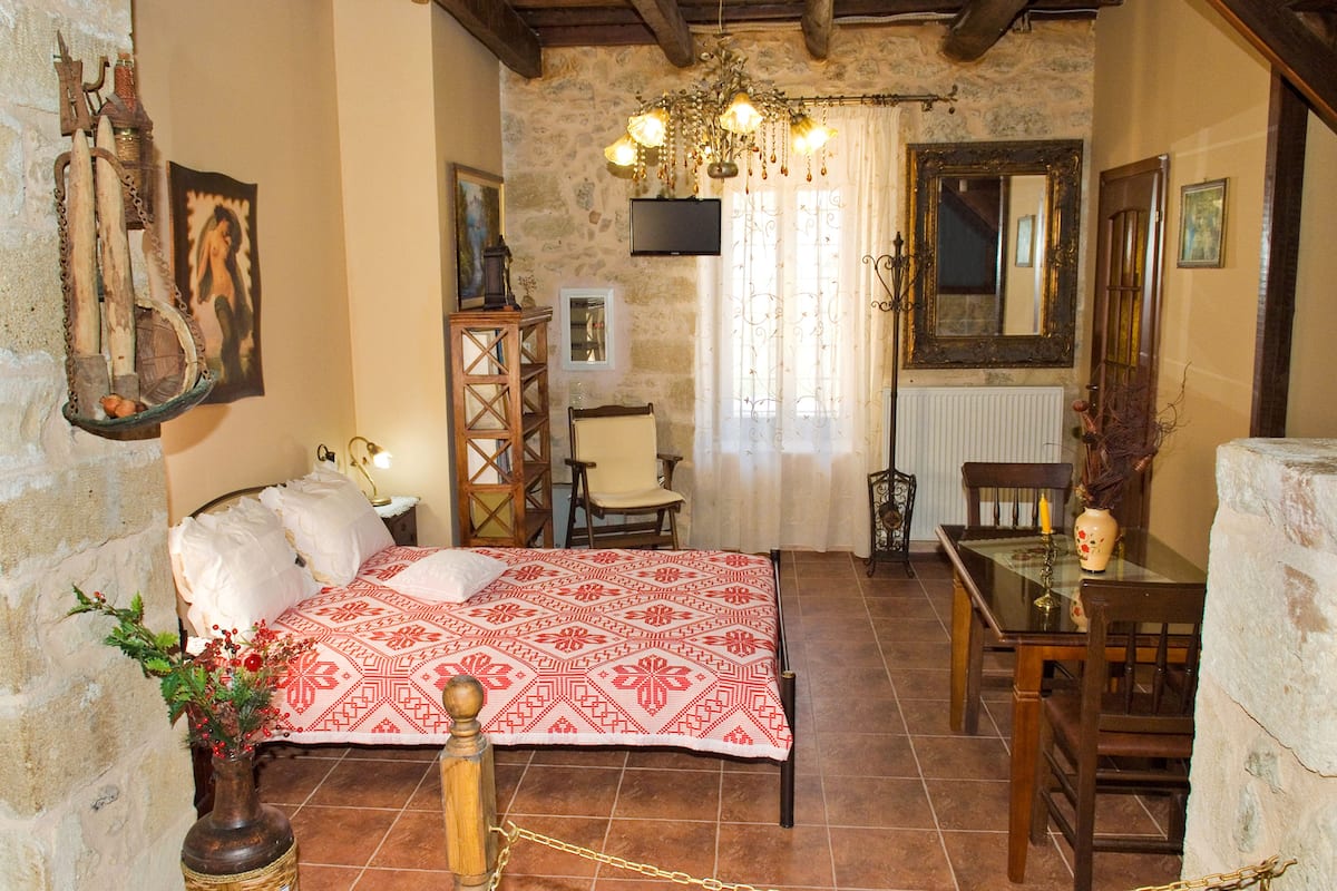 Une chambre à coucher avec un lit, une chaise, une table et un miroir.