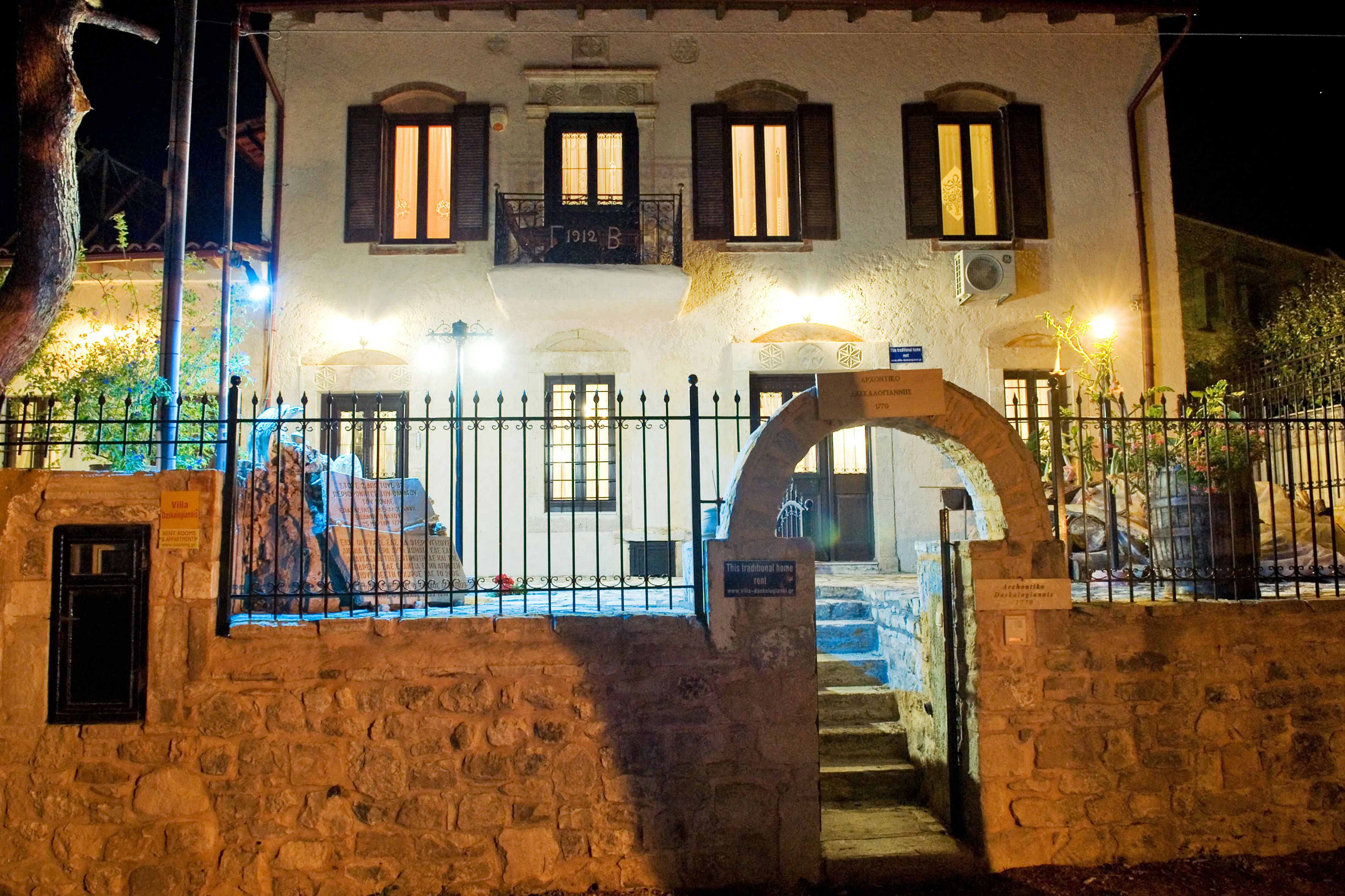 Un edificio de piedra tradicional con un portón de piedra, varias ventanas y un cartel que indica que es una casa histórica.