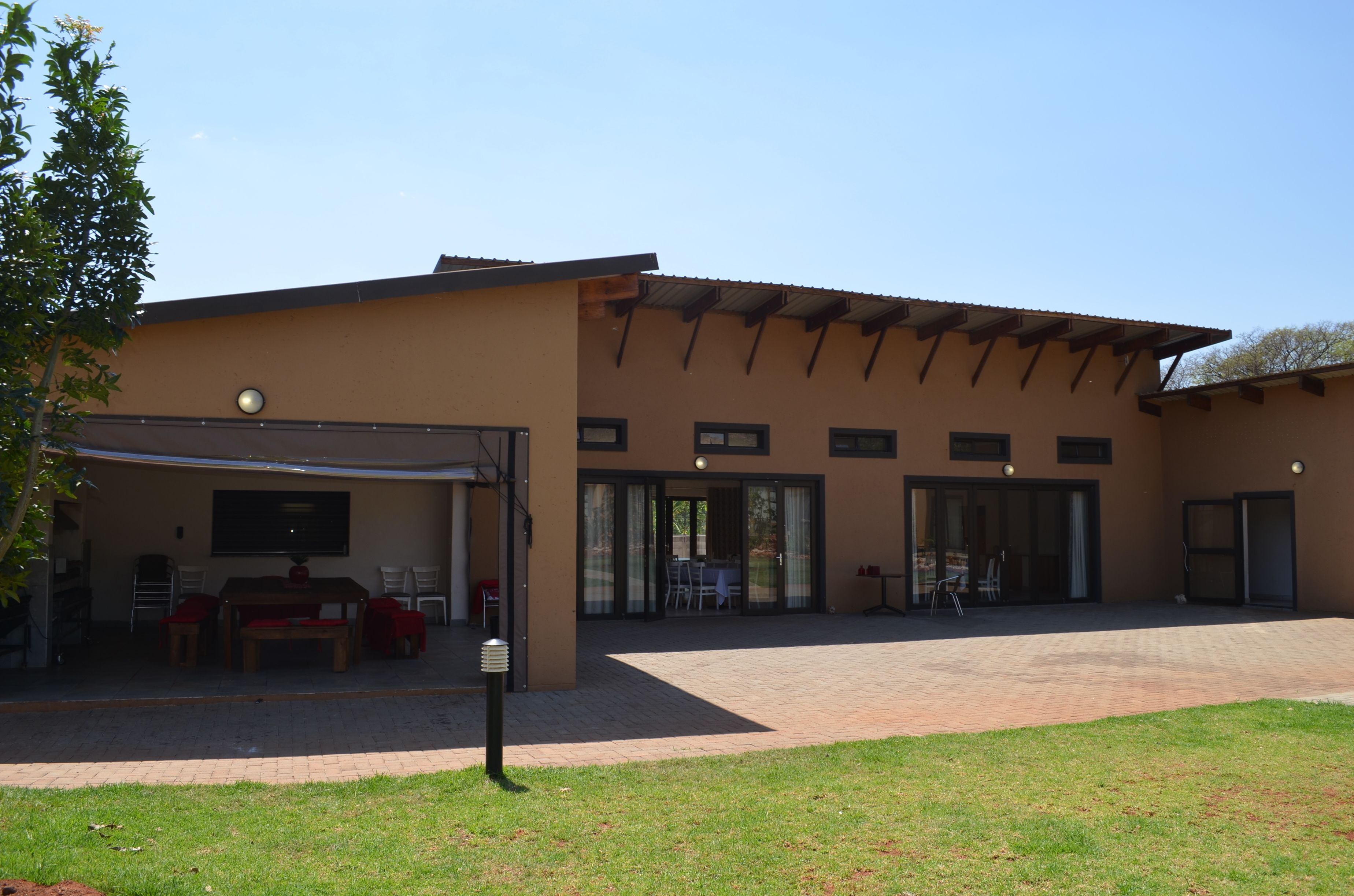 Een gebouw met een overdekte patio, een eethoek en een ruime open ruimte.