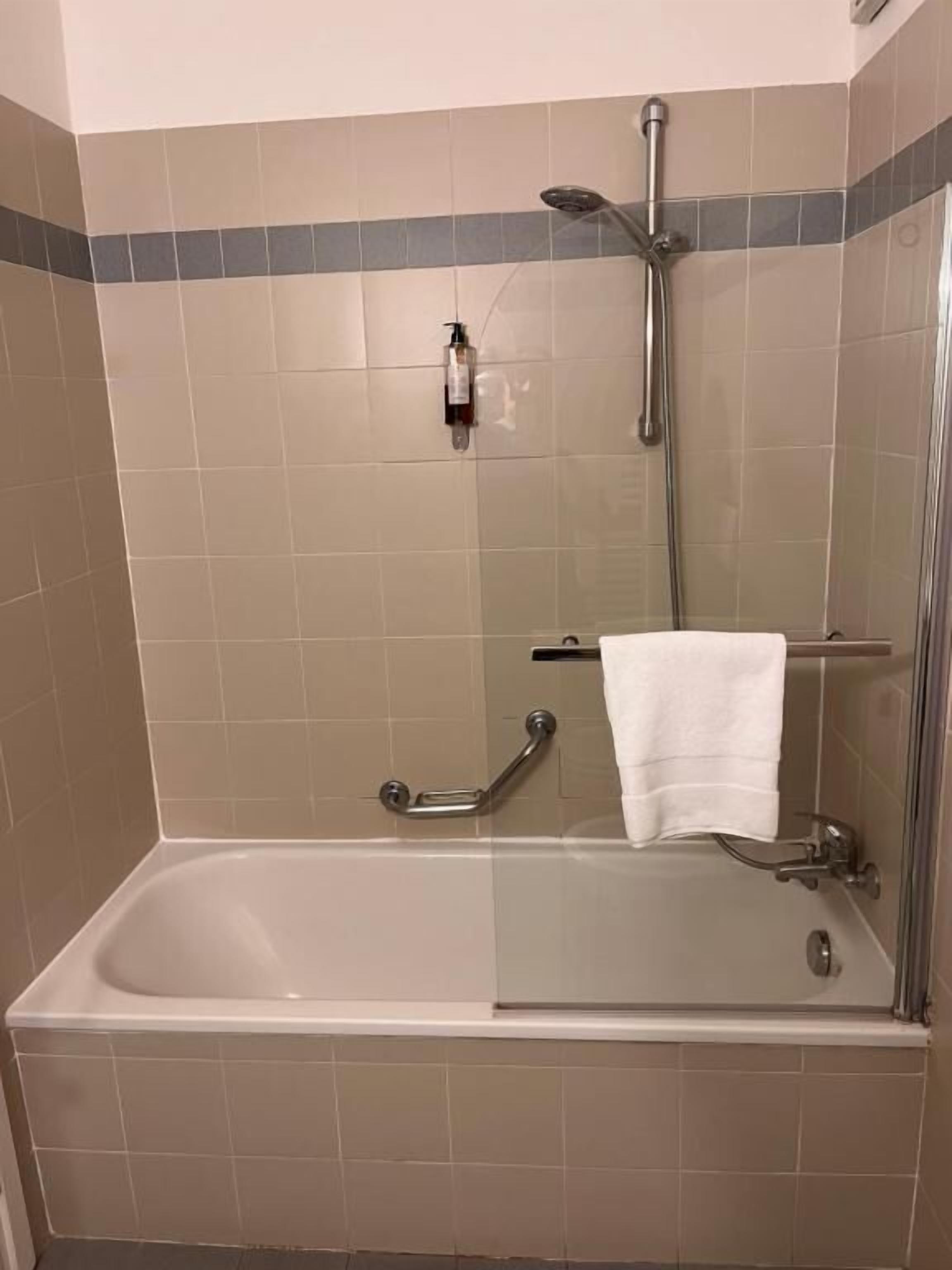 A bathroom with a bathtub, a shower, and a glass-enclosed shower stall.