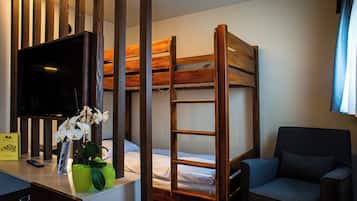 A hotel room with a bunk bed, a desk with a television, a chair, and a potted plant.