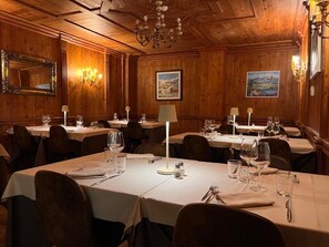 A dining area with multiple tables, each set with cutlery, glasses, and a lamp. - Hotel de Champoluc (Ayas)