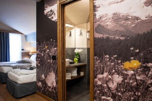 A hotel room with a bed, a bathroom, and a wall with a mountain landscape mural. - Hotel de Champoluc (Ayas)