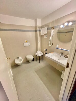 A bathroom with a bidet, toilet, sink, and mirror. - Hotel de Champoluc (Ayas)