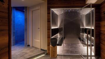 Un intérieur moderne avec un ascenseur en verre, un plancher en bois et une porte donnant sur un espace éclairé de lumière bleue.
