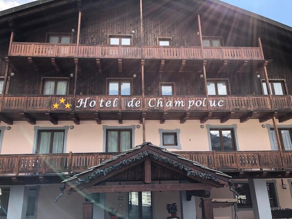 A hotel with a wooden facade, balconies, and a sign reading "Hotel de Champoluc". - Hotel de Champoluc (Ayas)