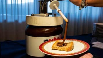 Une main tenant une assiette sur laquelle se trouve une part de gâteau et un pot de Nutella.