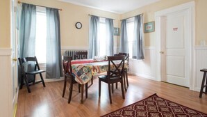 A dining area with a table set for four, wooden chairs, and a patterned tablecloth. - Apartments in Salem (Salem)