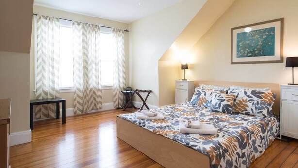 A bedroom with a bed, a desk, a chair, a ceiling fan, and a painting on the wall. - Apartments in Salem (Salem)