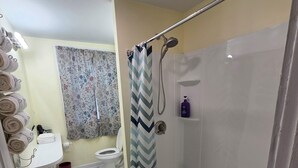 A bathroom with a shower, toilet, and sink.