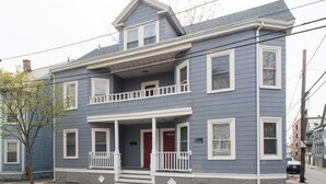 A two-story house with a front porch, a red door, and a small balcony. - Apartments in Salem (Salem)