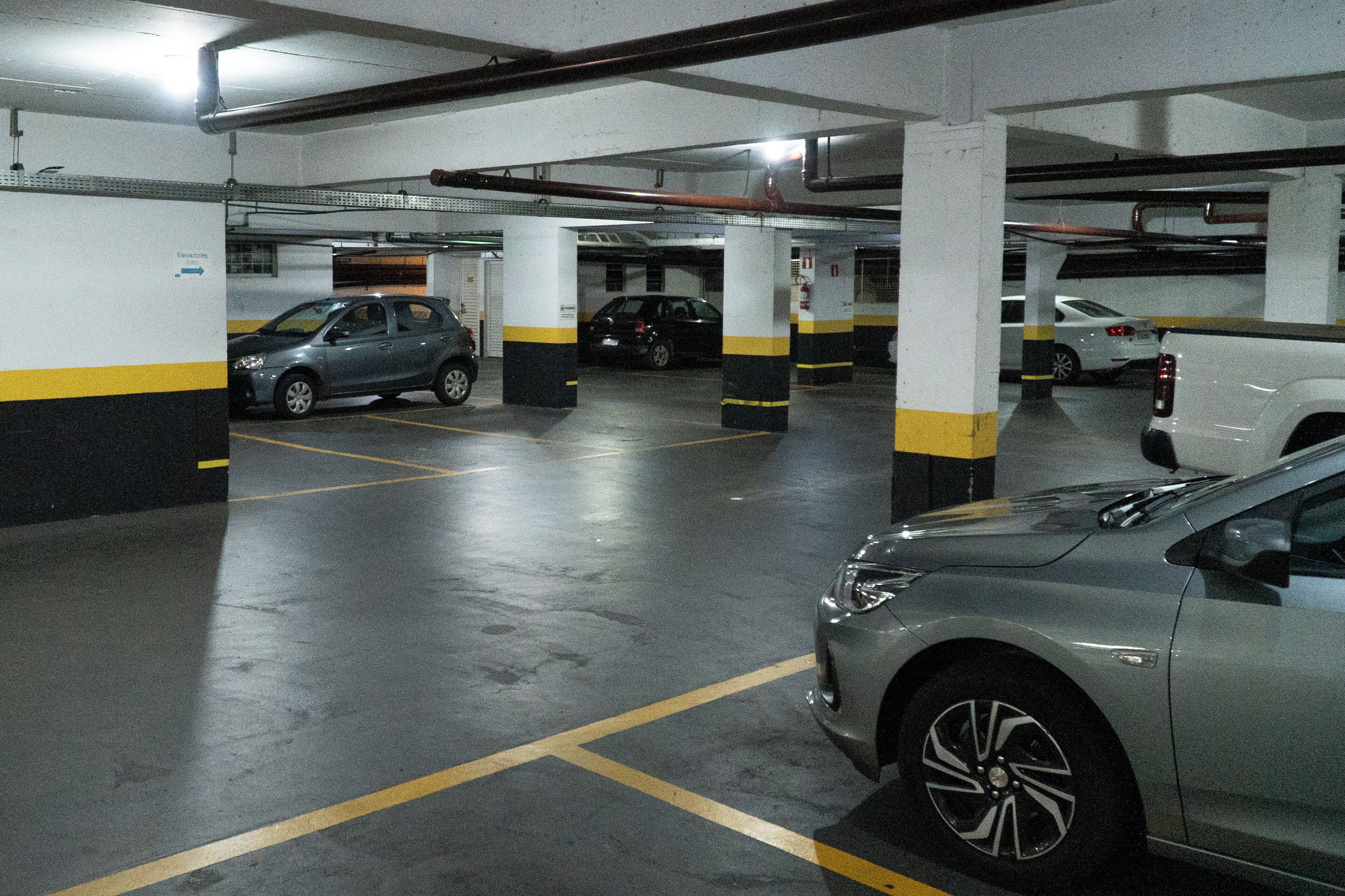 Um parque de estacionamento com vários andares e diversos carros estacionados.