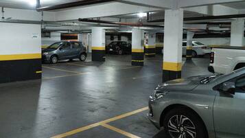 Um parque de estacionamento com vários andares e diversos carros estacionados.