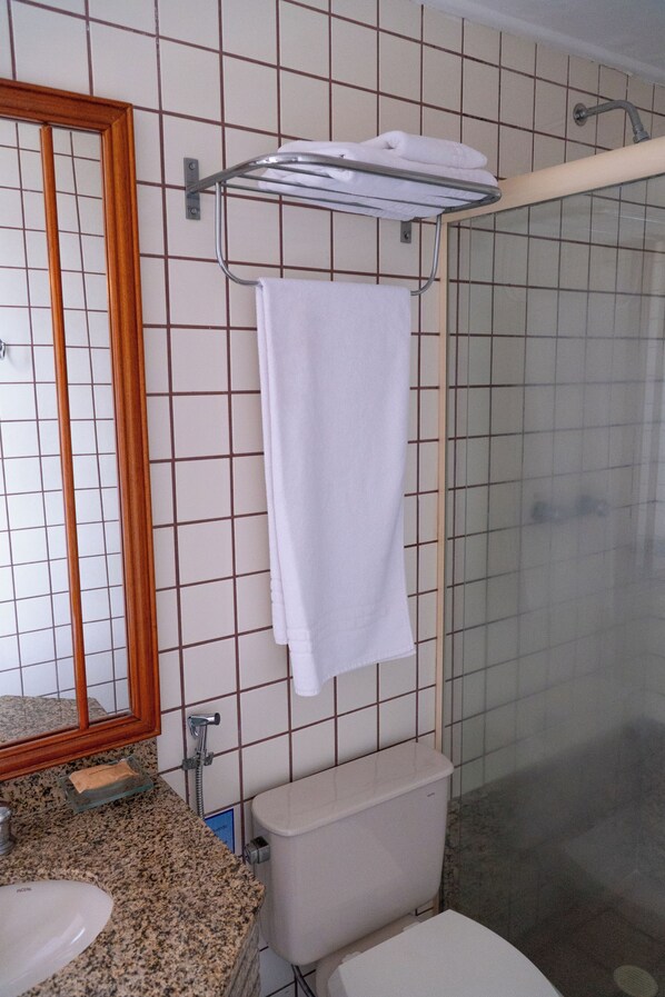 A bathroom with a sink, toilet, and a towel rack with a towel. - New Life Piracicaba by Atlantica (Piracicaba)