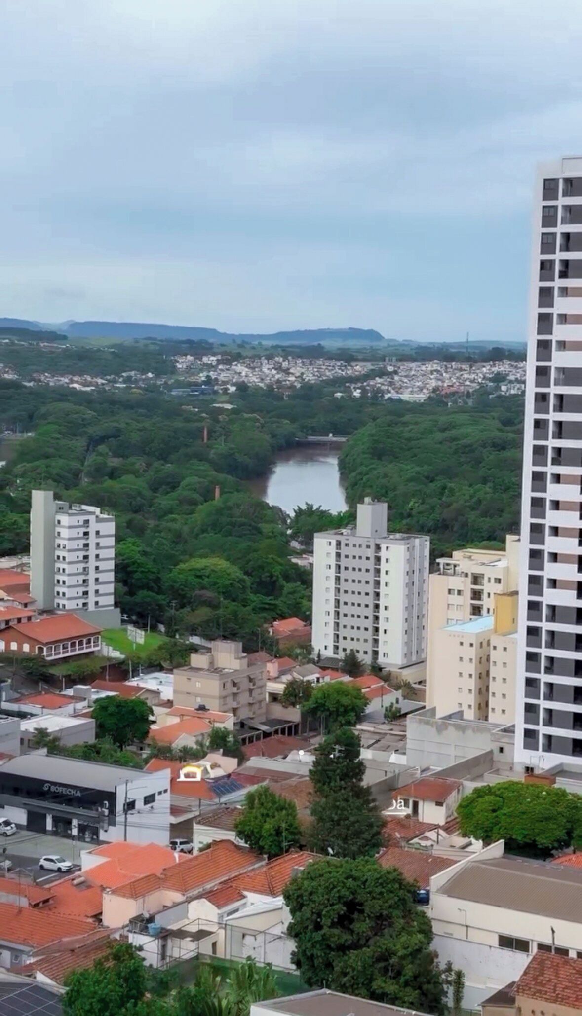 A cityscape with a river, buildings, and greenery.