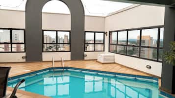 Een binnenzwembad en ligstoelen