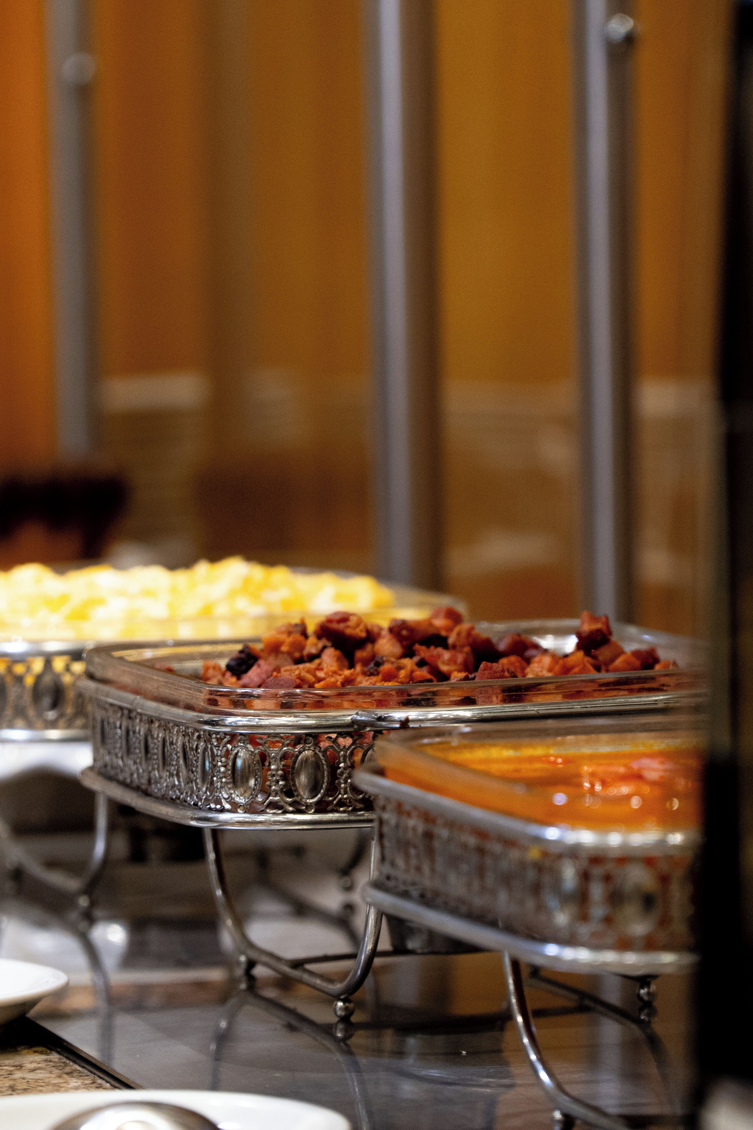 A buffet with various dishes in glass containers.