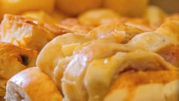 Una exhibición de productos horneados varios, incluyendo panes y pasteles.