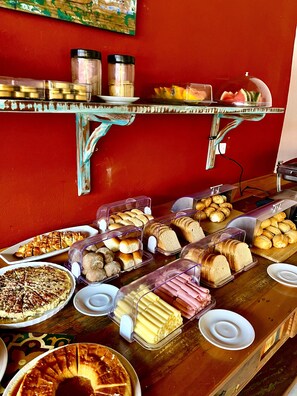 A buffet with various food items including pastries, bread, and a pie.