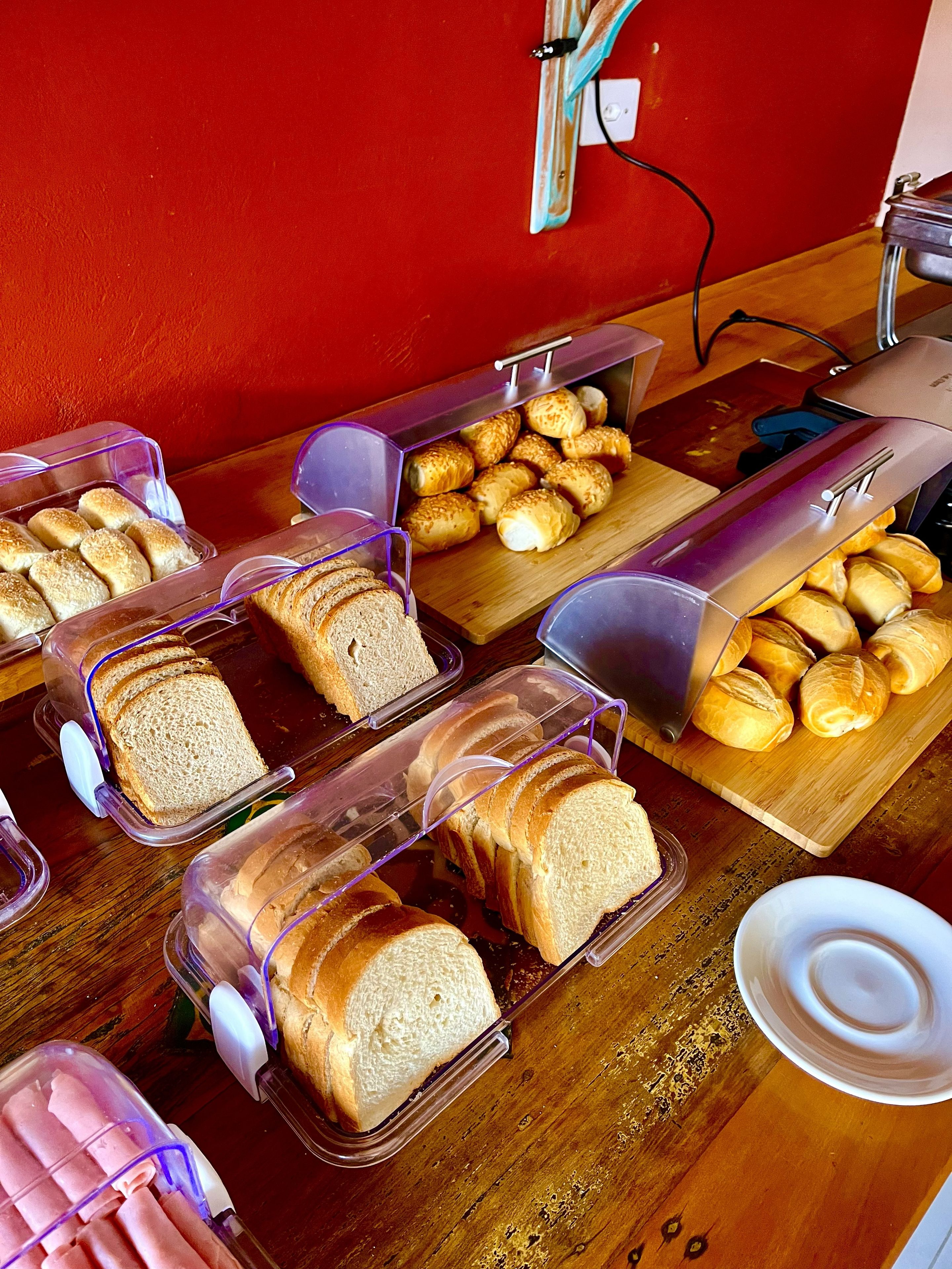 Una mesa de buffet con panes y pasteles varios.