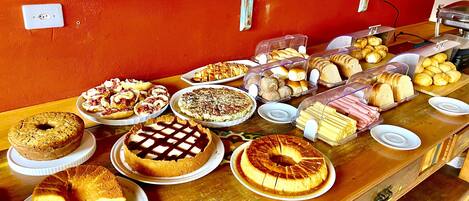 Un bufé con diversos productos de panadería y postres.