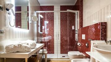 Ein modernes Badezimmer mit Holzboden, zwei Waschbecken, einer Toilette und einer Duschkabine.