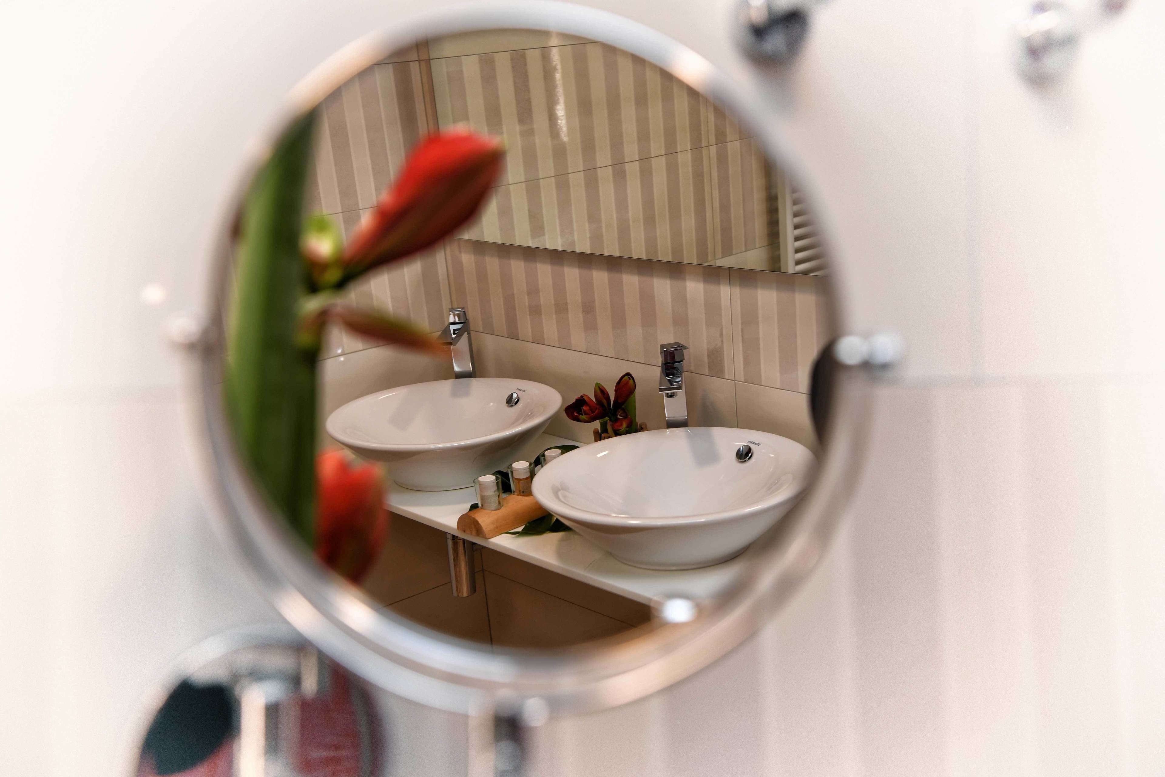 Une salle de bain avec deux lavabos, un miroir et un porte-serviettes.