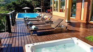A wooden deck with a hot tub, lounge chairs, and a swimming pool. - Top de Buzios Boutique (Búzios)