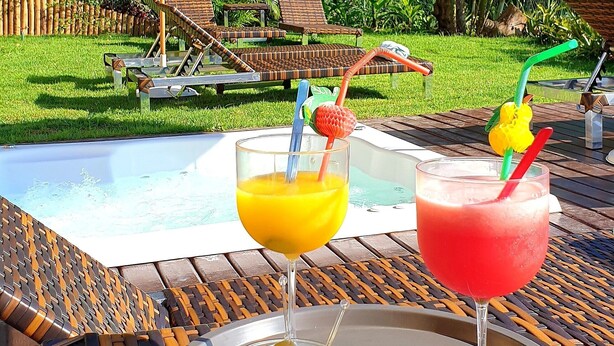 A poolside area with lounge chairs, a table with drinks, and a pool. - Top de Buzios Boutique (Búzios)
