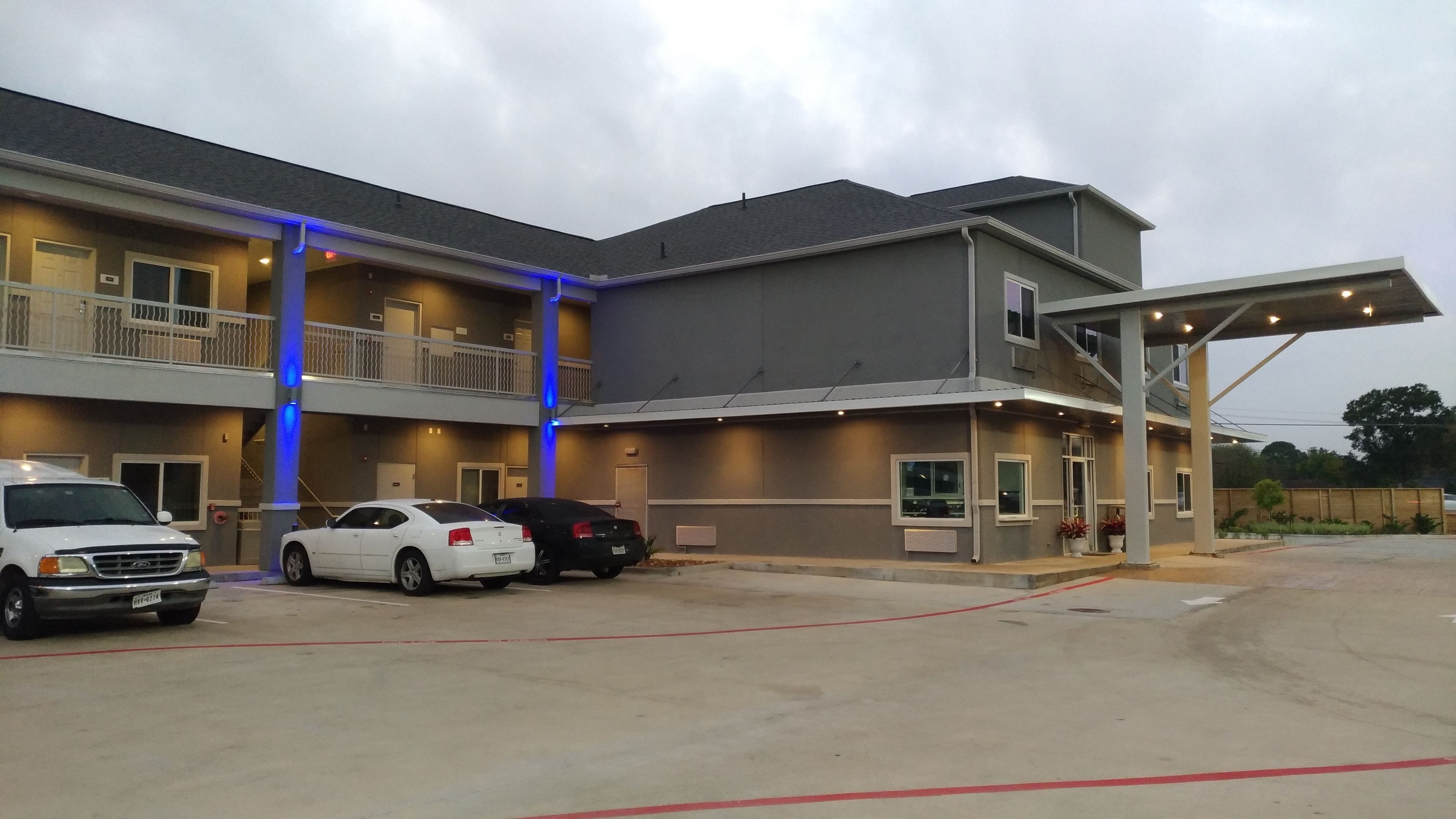 A multi-story hotel with a covered entrance and a parking lot.