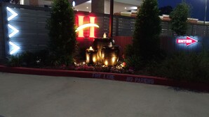 A hotel entrance with a 'Fire Lane' sign, a 'No Parking' sign, and a large illuminated 'H' sign. - Haven Inn & Suites Downtown Houston (Houston)