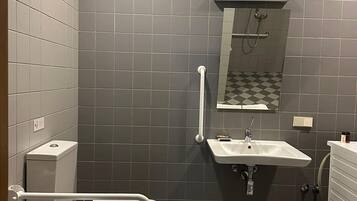 A bathroom with a toilet, sink, and mirror.
