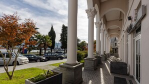 A building with a covered walkway, columns, and planters. - Le Port Apart Hotel (Batumi)