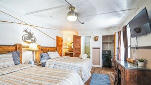 A bedroom with two beds, a desk, a television, and a kitchenette. - Hotel Eastin (Kremmling)