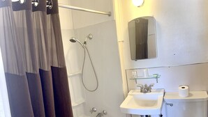 A bathroom with a bathtub, a shower, a sink, and a toilet. - Hotel Eastin (Kremmling)