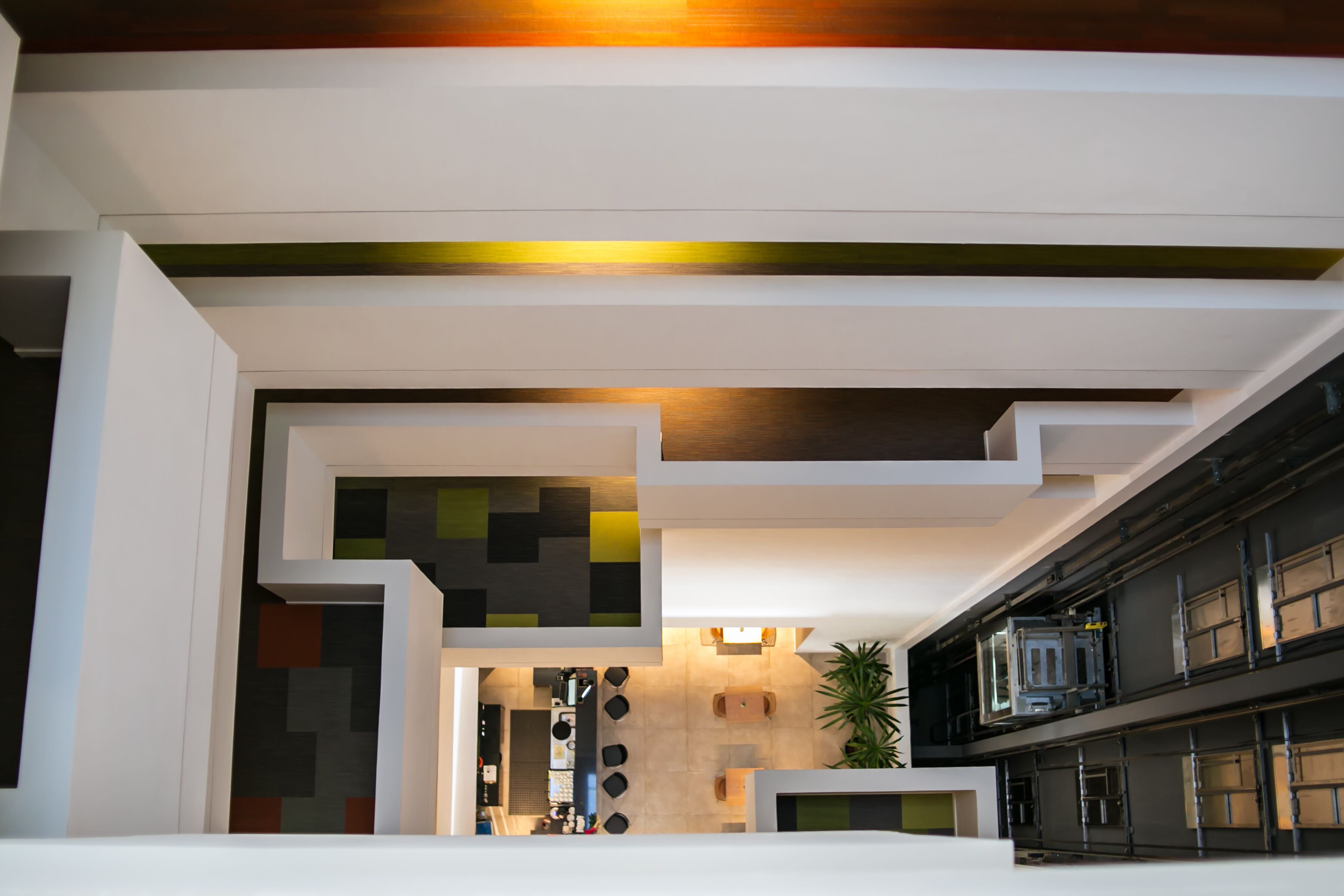 A modern interior with a kitchen area, dining space, and a staircase.