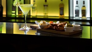 Un bar amb un got de martini i una safata de menjar.
