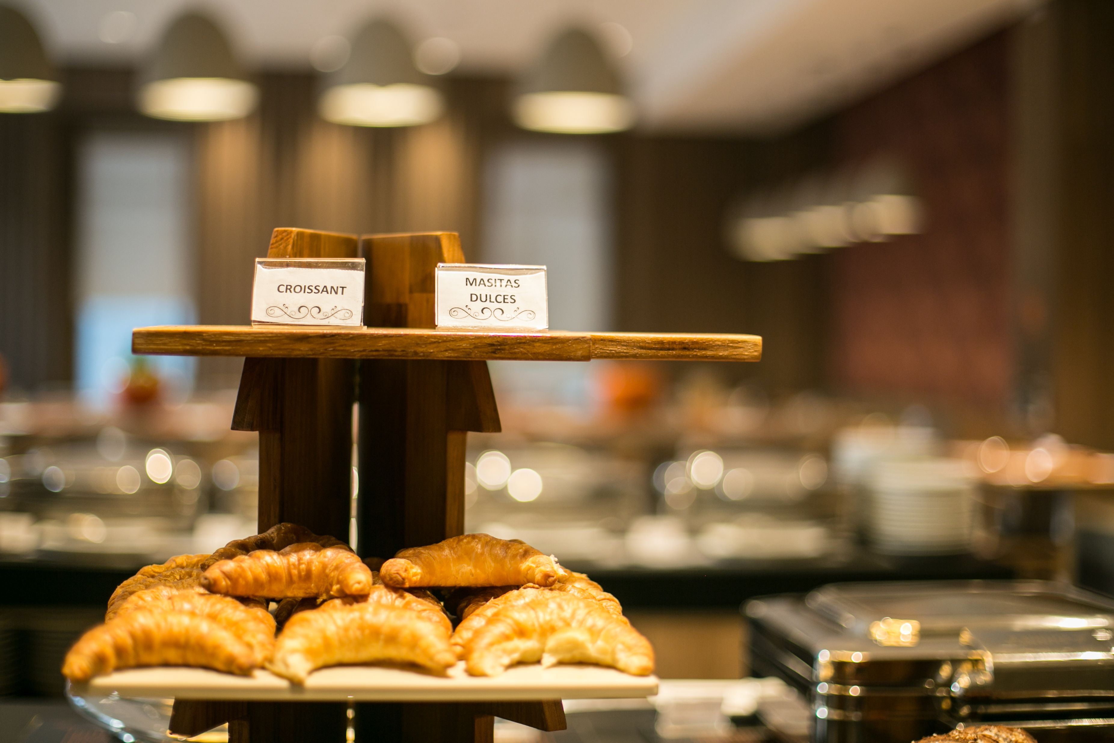 A buffet with labeled sections for croissants and sweet pastries.