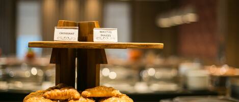 A buffet with labeled sections for croissants and sweet pastries.