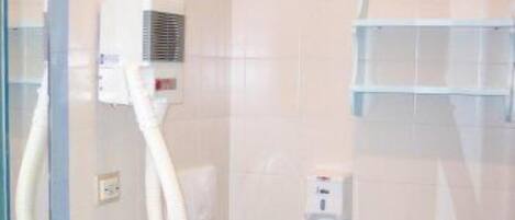 A bathroom with a toilet, sink, and shower area.