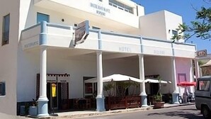 Een hotel met twee verdiepingen, een overdekt terras en een restaurant.