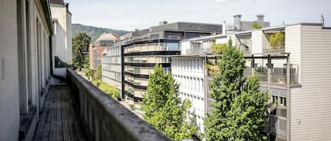 Un balcón con vistas a edificios modernos y árboles.
