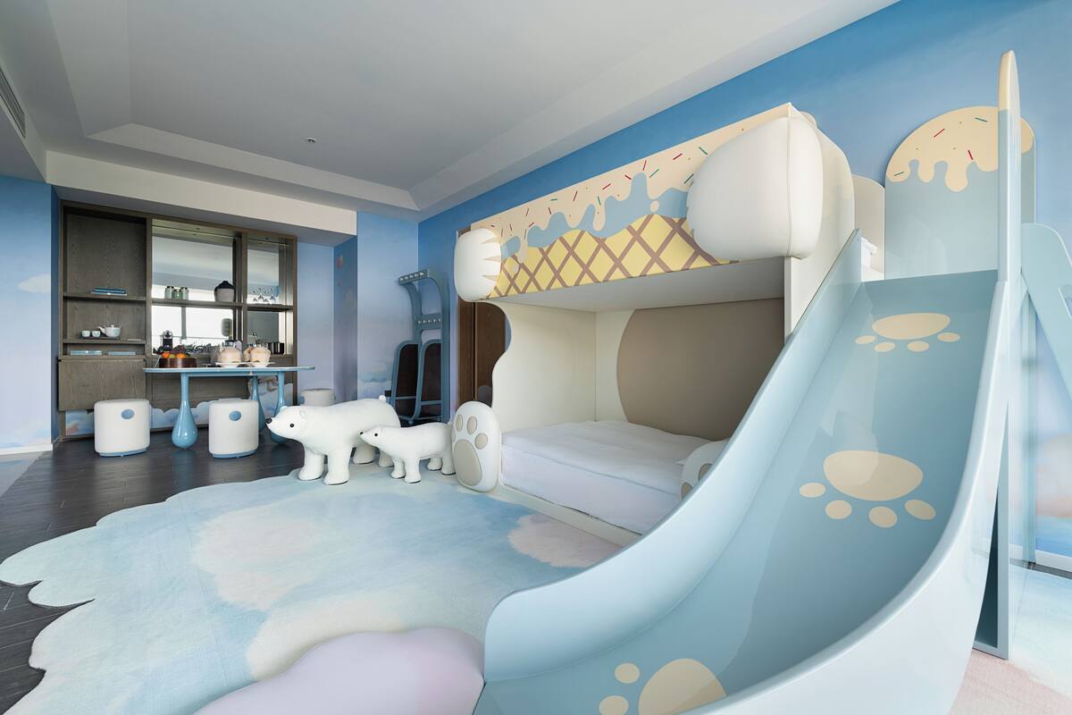 Un cuarto de juegos para niños con un tobogán, una cama y una zona de juegos.