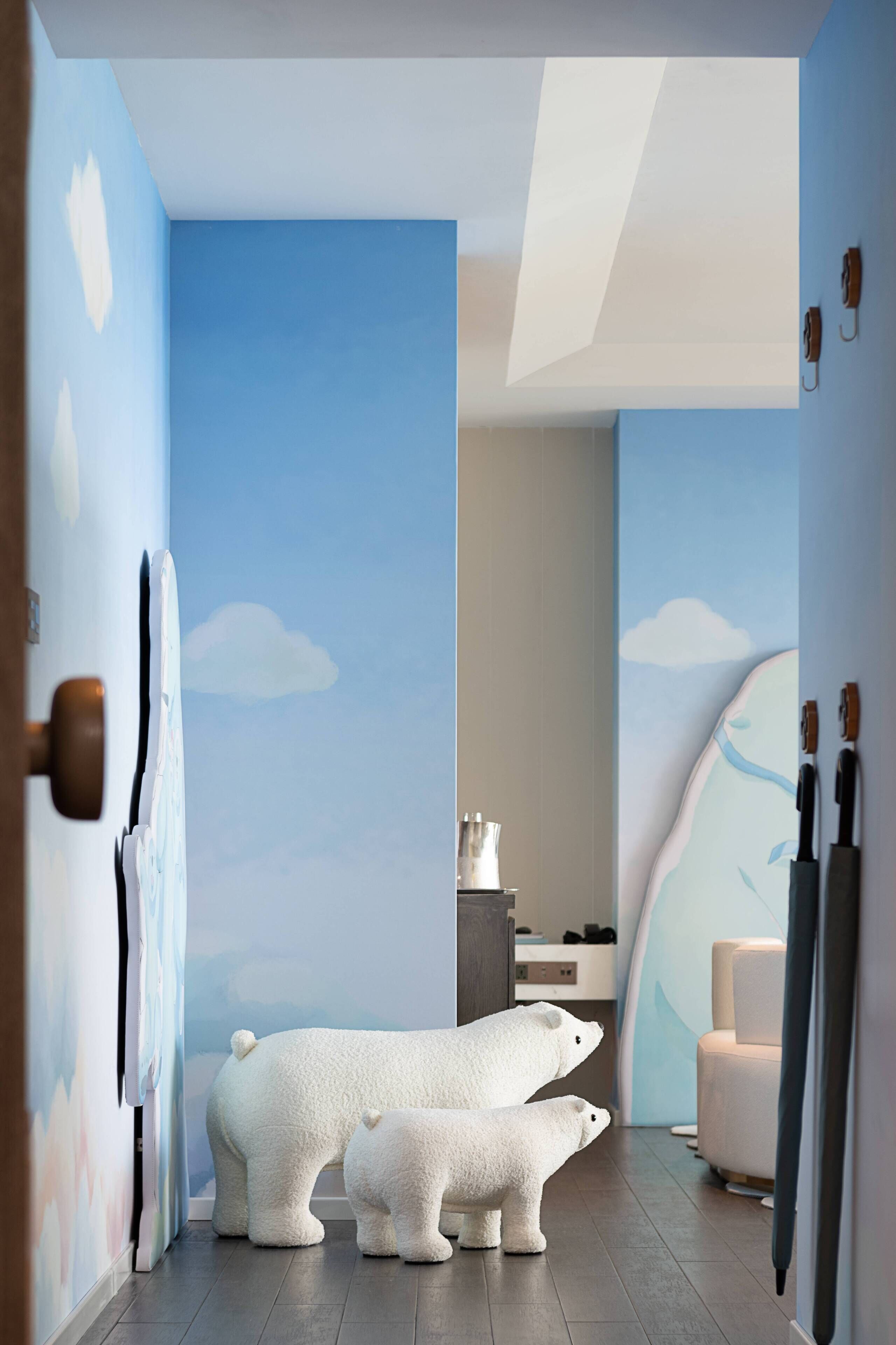 Een gang met een muurschildering van een ijsbeer, een moderne badkamer en een zithoek.