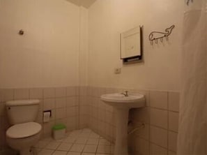 A small, tiled bathroom with a toilet, sink, and a towel rack. - GoHouse - Jau Sp 23 (São Paulo)