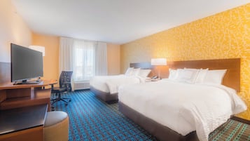 A hotel room with two beds, a desk with a TV, and a chair.